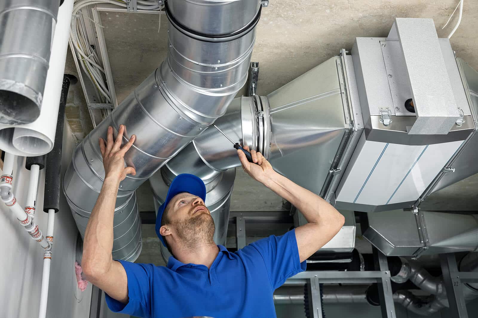 HVAC technician inspecting and repairing air ducts in Dana Point