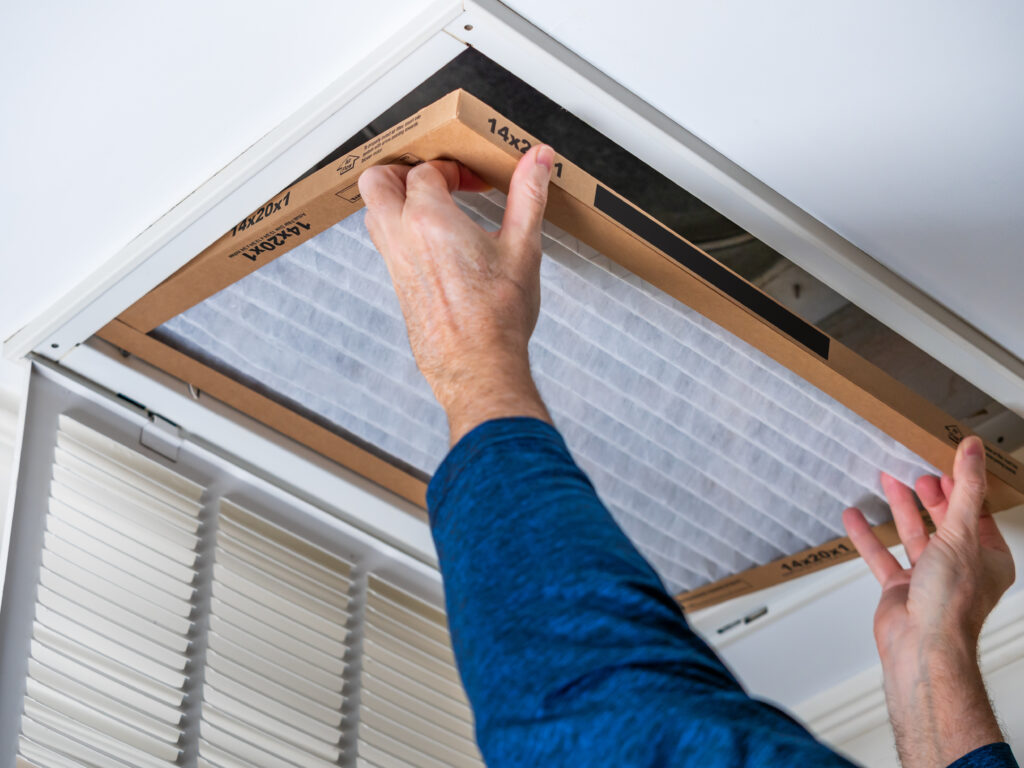 HVAC technician replacing a home air filter in Dana Point