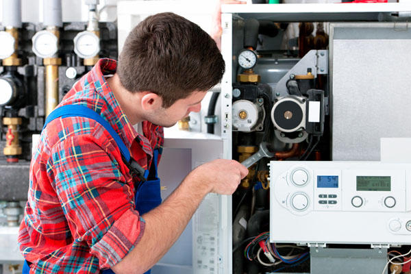 Heating technician repairing boiler controls in Dana Point