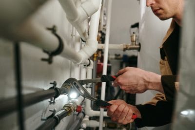 Technician inspecting commercial plumbing pipes in Dana Point