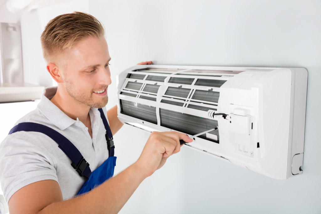 HVAC technician maintaining a ductless air conditioner in Dana Point