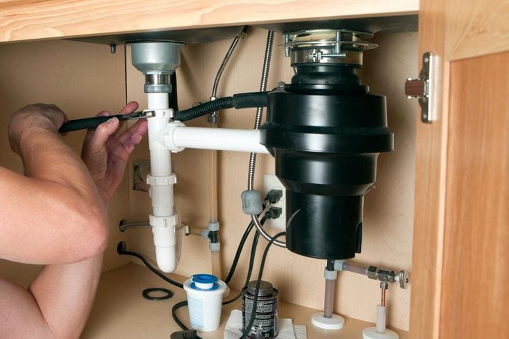 Plumber repairing a garbage disposal in Dana Point