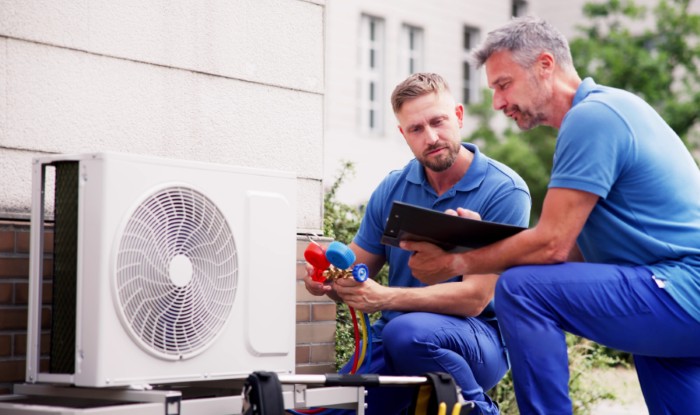 HVAC technicians installing an outdoor air conditioning unit in Dana Point
